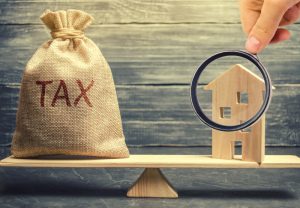 Wooden,House,And,A,Money,Bag,With,The,Word,Tax
