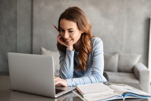 Portrait,Of,A,Beautiful,Young,Woman,Studying,While,Sitting,At