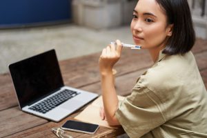 Portrait,Of,Young,Asian,Woman,Working,On,Laptop,,Screen,Is