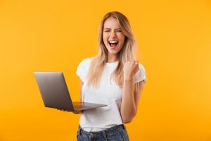 Portrait,Of,An,Excited,Young,Blonde,Girl,Holding,Laptop,Computer