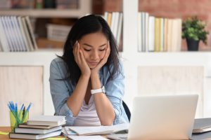 Asian,Ethnicity,Student,Girl,Sitting,At,Table,Full,With,Books