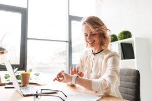 Image,Of,Cheerful,Young,Business,Woman,Sitting,In,Office,Using