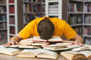 Student,Studying,Hard,Exam,And,Sleeping,On,Books,In,Library,