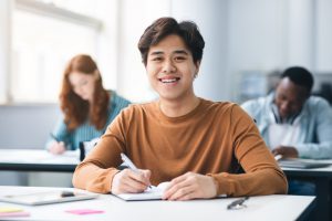 Modern,Education,Concept.,Portrait,Of,Smiling,Asian,Male,Student,Sitting