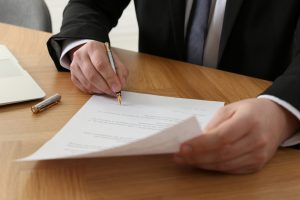 Notary,Signing,Document,At,Wooden,Table,,Closeup