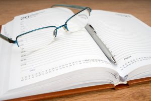 Daily,Planner,With,Glasses,And,Pen,On,The,Table