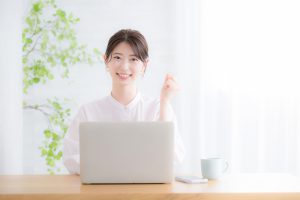 Smiling,Woman,Looking,At,Camera,In,Front,Of,Computer,Image
