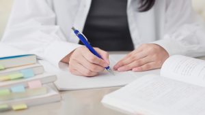 Asian,Woman,Studying,With,A,Reference,Book